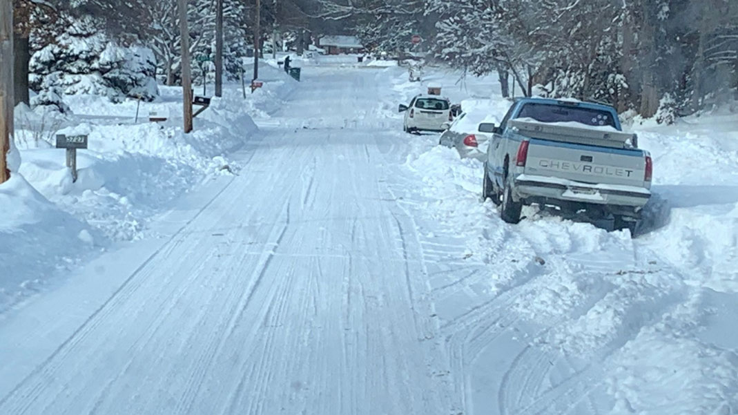 Image showing cars parked on one side of the street, with the other side of the street plowed