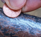 Lead pipe scratched with a penny