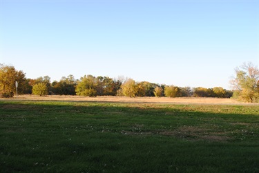 Bison trail is a paved hiker biker trail that runs along green open park space and native prairies and wooded areas.