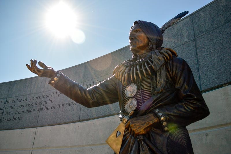 Chief Standing Bear, of the Ponca tribe, stands larger than life, immortalized in bronze. He is dressed as he may have been for the trial that made him a civil rights icon, with an eagle feather in his hair, a bear claw necklace, holding his axe.
