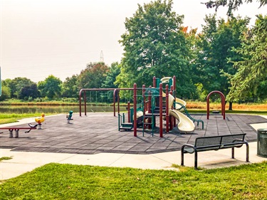 Peterson Park’s playground features a multi platform structure, see saw, spring riders, tire swing, bucket swings, and belt swings on rubber tiles. There are benches, large shade trees, and Beal Slough nearby.