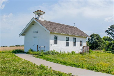 A white single room schoolhouse is one of the buildings at Pioneers Park Nature Center.