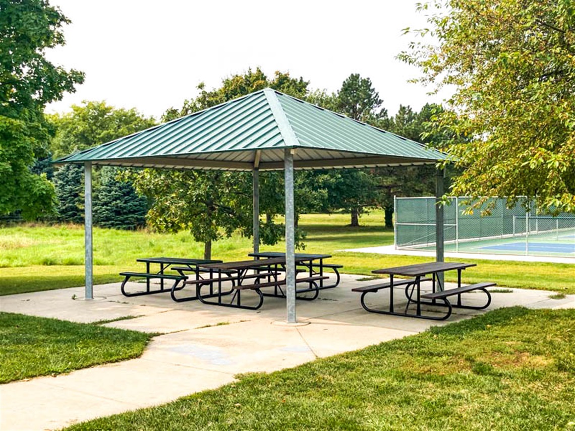 This open shelter is located near the tennis courts inside of Peterson Park. It has a concrete foundation that is connected to the paved path.