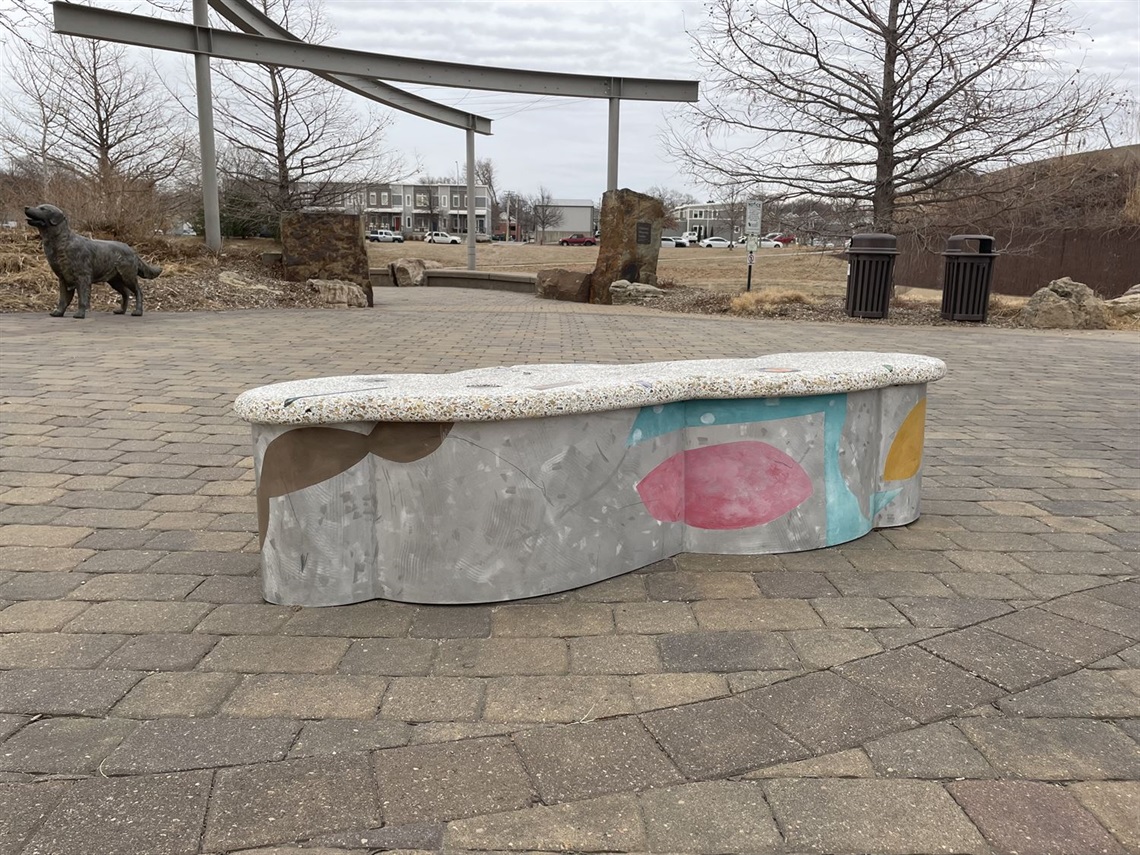 A mix of color and grey stone creates this lumpy cloud shaped bench