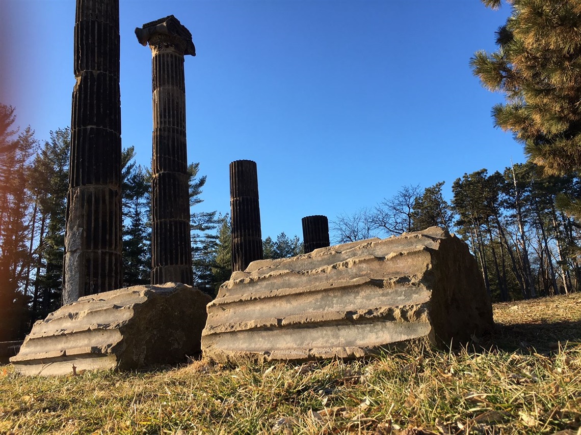 Sandstone columns rising high into the air while other lie prone on the ground on a fall day.