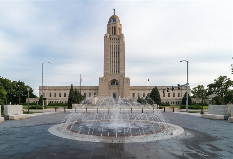 The Capitol building stands tall behind the streams of water of the State Seal Fountain