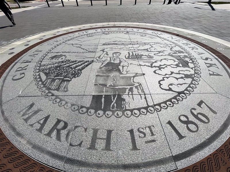 Engraved stones make up the Nebraska state seal on the ground. 