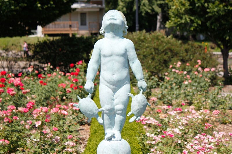The sculpture Turtle Baby surrounded by roses in the Hamann Rose Garden
