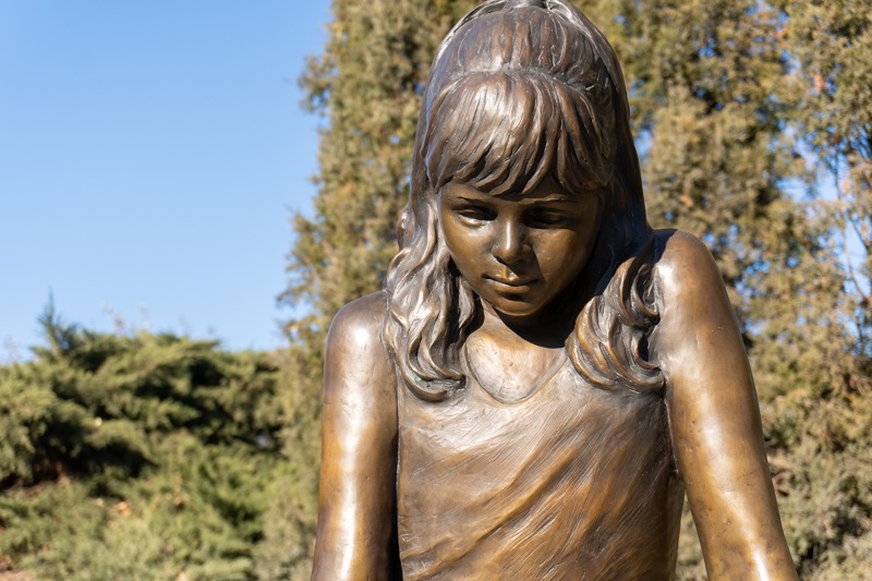 A close up on the face of the bronze figure of a young girl, Inspiration