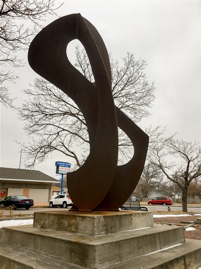 A winding and twisting form made of rusted steel. 
