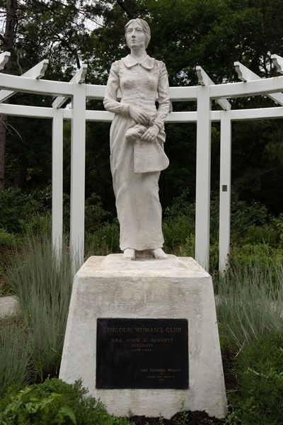 Full body image of a sculpture of a pioneer woman