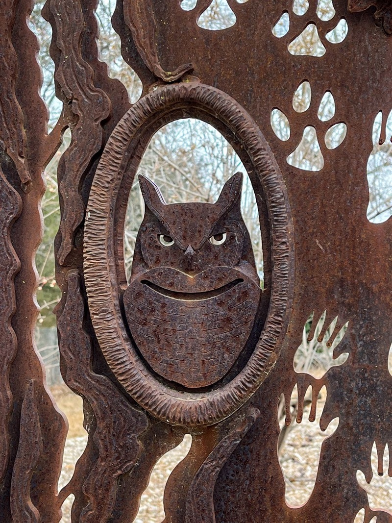 Nestled in the middle of one of the Pioneers Park Nature Center entry panels is a metal owl. 