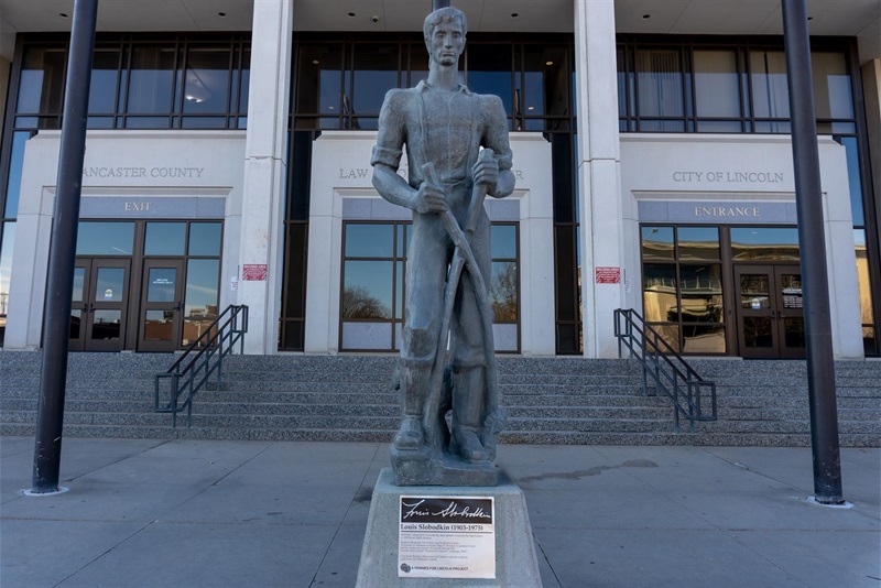 full image of the young Abraham Lincoln sculpture, standing on a pedestal outside the city/county building