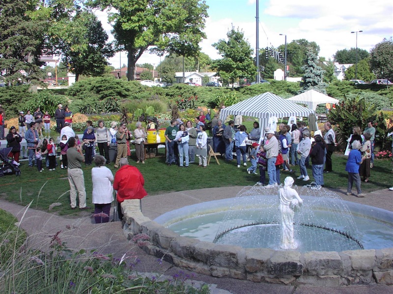 A gathering of people at Sunken Gardens, and in the bottom right corner stands the original Rebekah at the Well sculpture in the fountain.