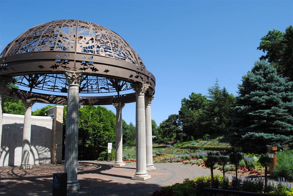 Looking into sunken gardens, with the rotary gazebo at the front left and trees on the far right. 