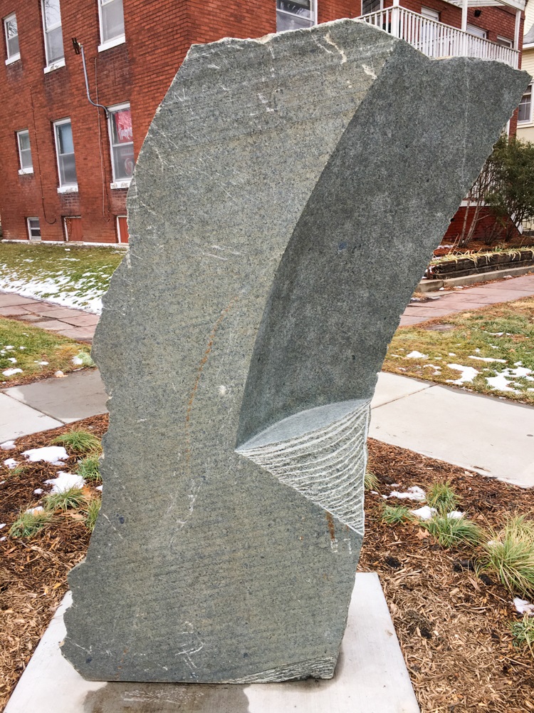 a slab of granite with man-made grooves, smooth planes, and natural edges
