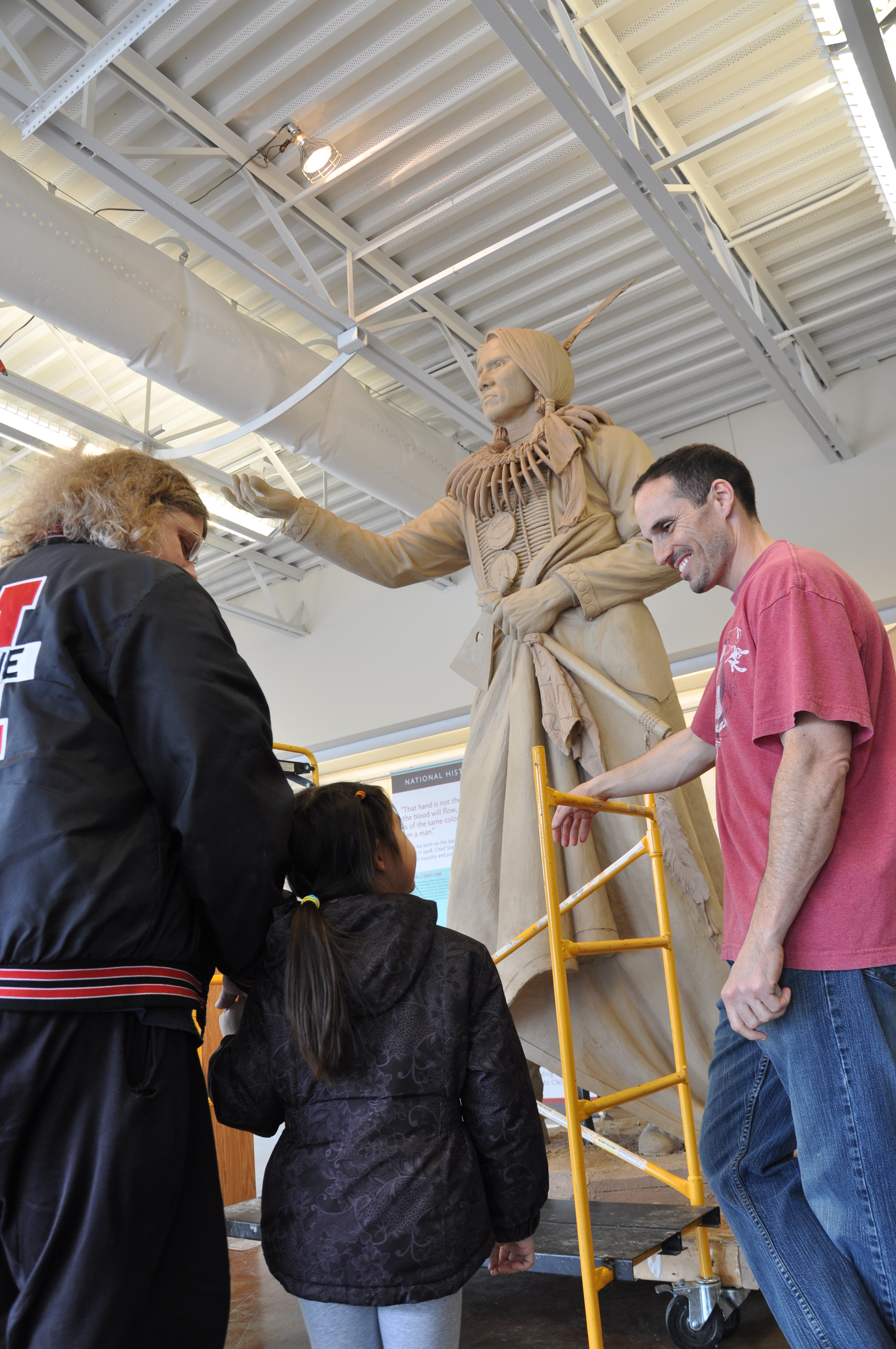 Ben Victor and visitors in front of the clay statue of Chief Standing Bear in the workshop