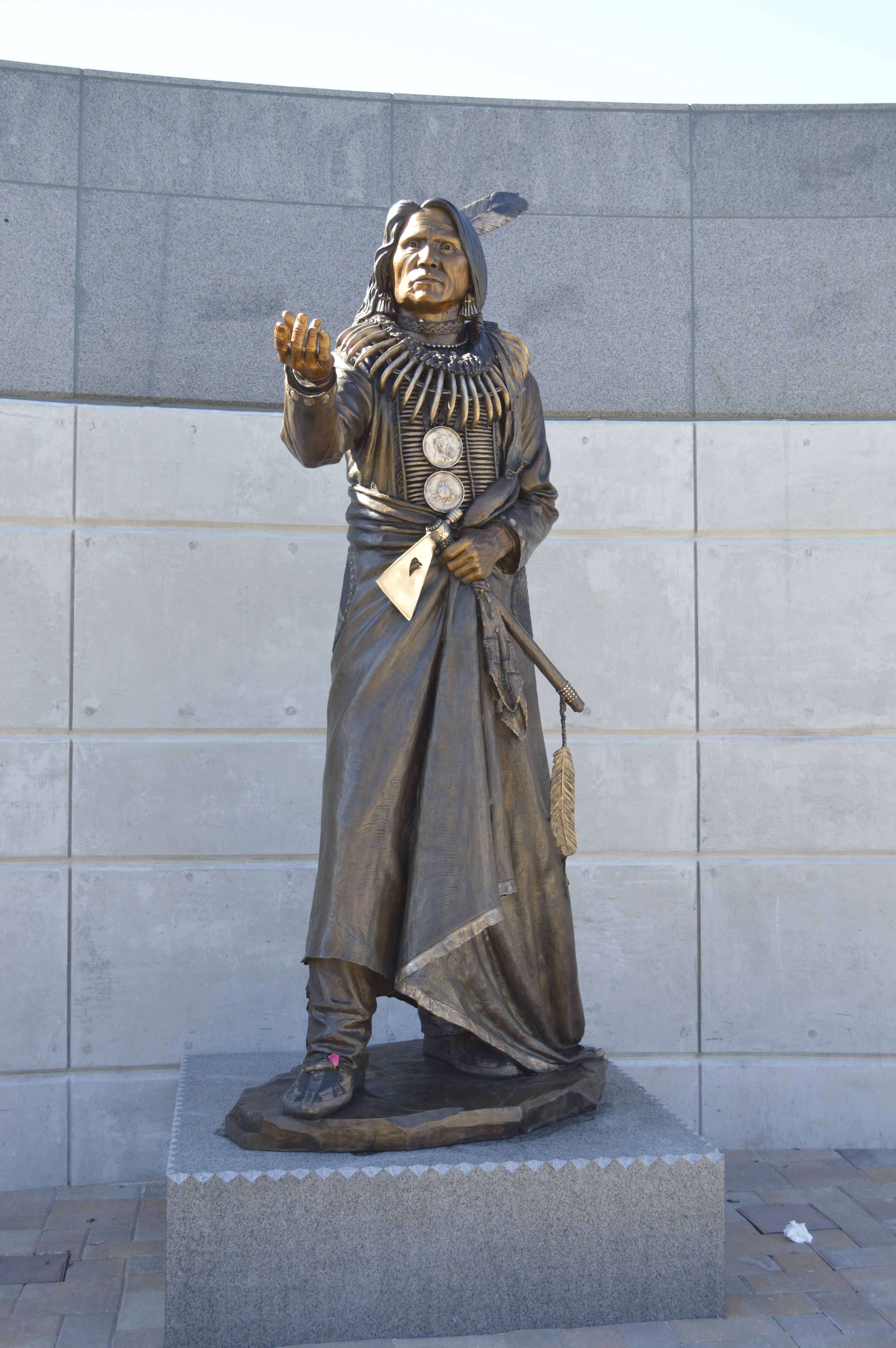 Bronze statue of Chief Standing Bear, standing holding a hand out
