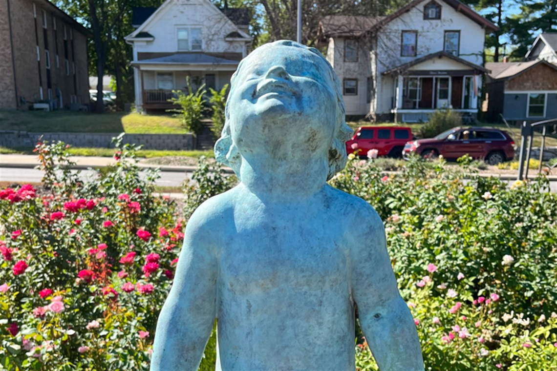 a close up of the young child sculpture smiling and basking in the sunlight