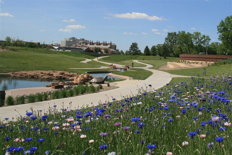 wide shot of Union Plaza trails, with flowers in the foreground and a bronze turtle near a water feature