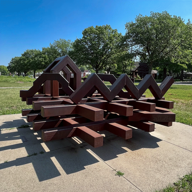rotating around the large metal geometric sculpture of a double grid base with various geometric squiggles balanced on top.