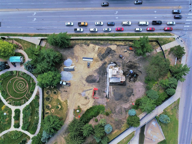 An aerial view of the Cascade Fountain under construction, the ground around the fountain has been bulldozed and there is heavy machinery. The rotary garden is on the left with it's brick spiral garden feature.
