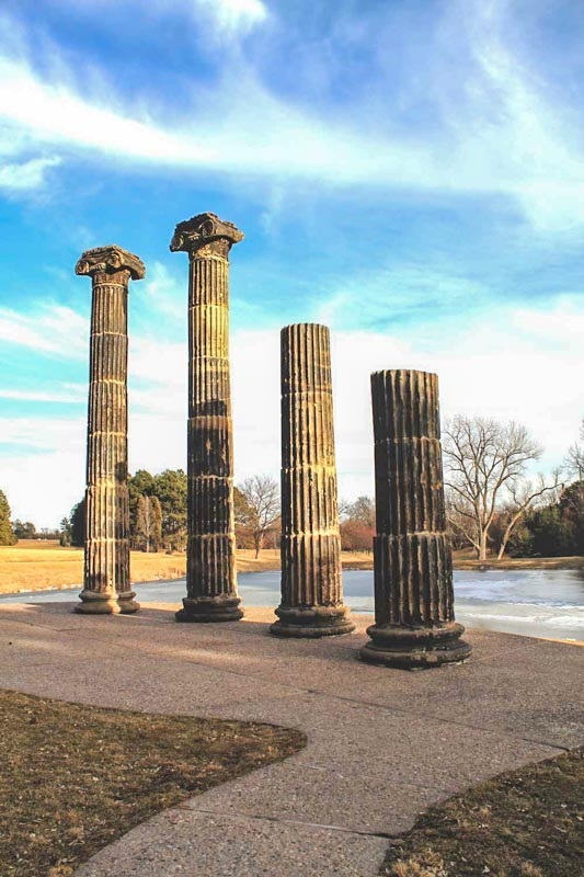 The Columns at Pioneer's Park, backdropped by blue sky with wisps of cloud. 