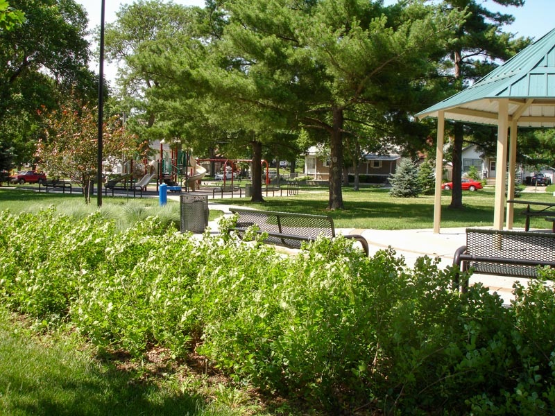 The gazebo and playground at American Legion Park are located underneath a mixture of evergreen and deciduous tree canopies. Picnic tables and benches provide ample options for picnics and relaxation. 